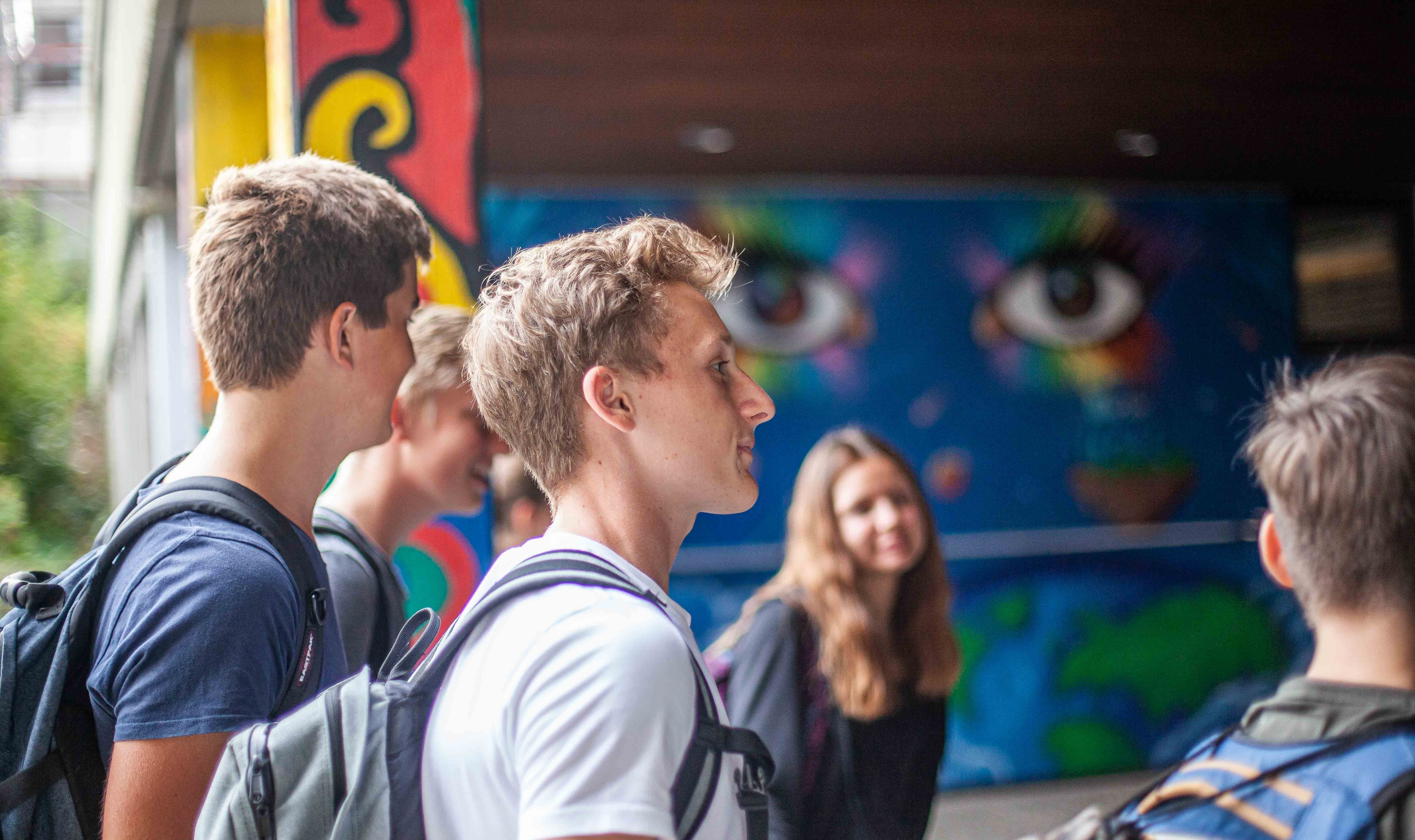 Schüler hören einer Ansprache auf dem Schulhof zu