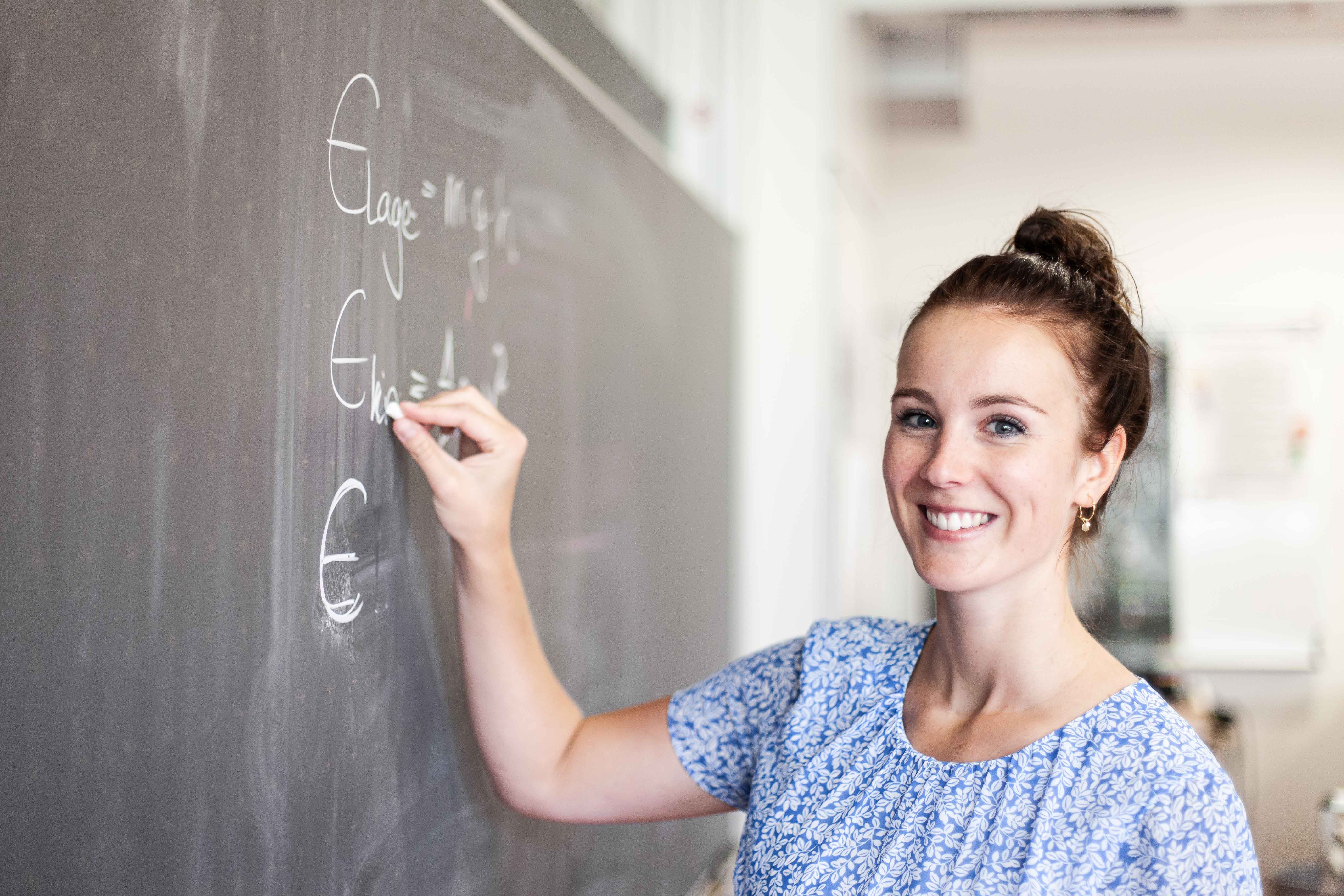Lehrerin schreibt an der Tafel