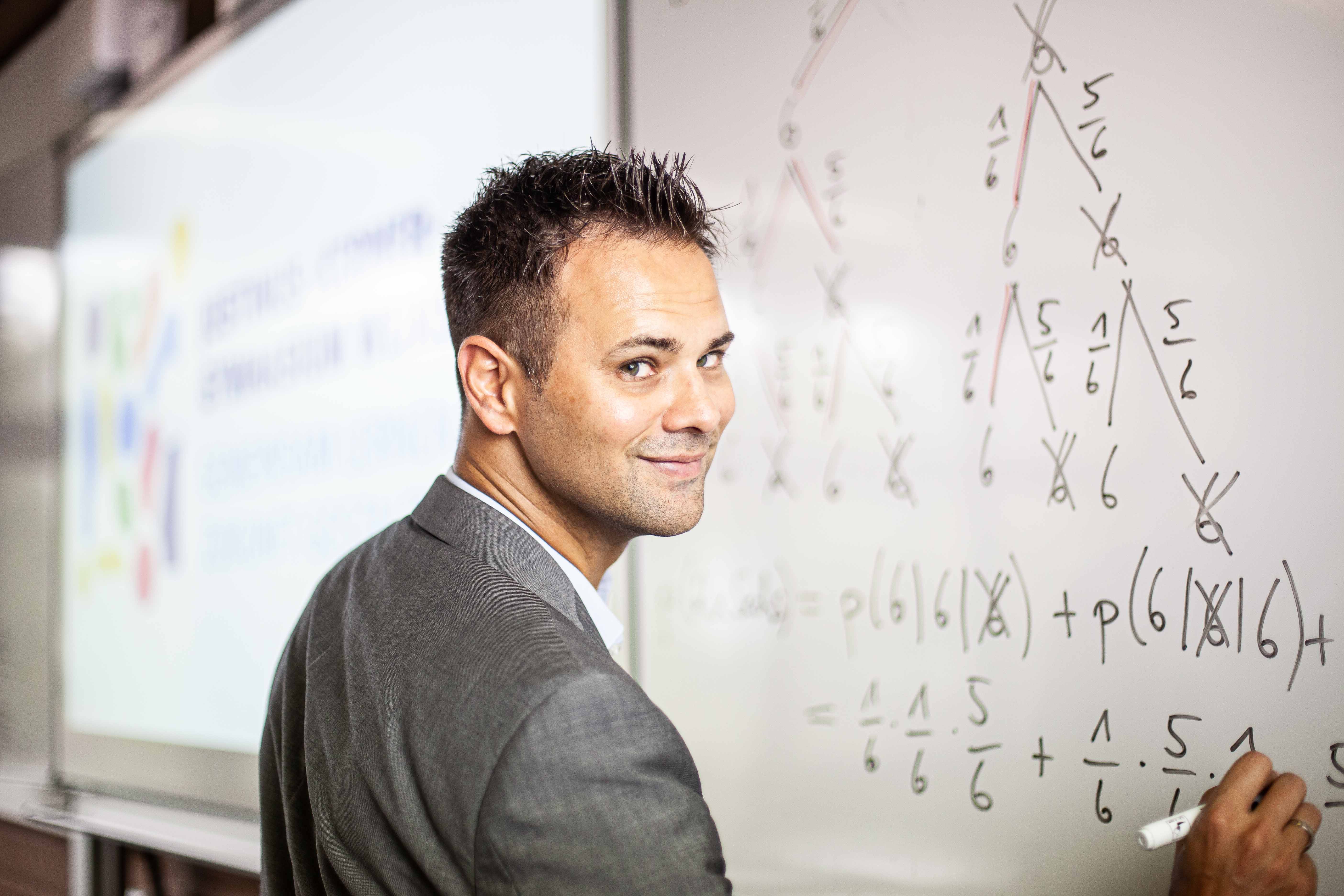 Junger Mathematiklehrer lehrt das Thema "Vektoren im dreidimensionalen Koordinatensystem"